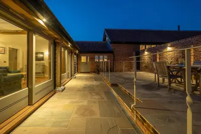 a patio with sliding glass doors and a table at Alde Bay Farm - Oyster Catcher in Aldeburgh
