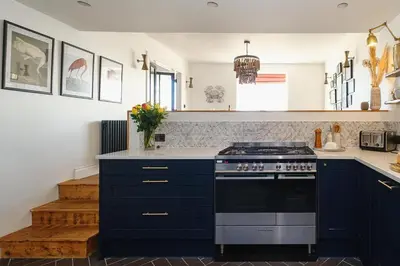 a kitchen with blue cabinets and a stove at Pembroke in Aldeburgh