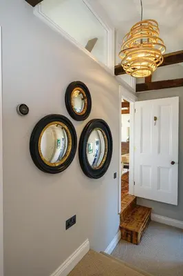 a hallway with three round mirrors on the wall at Pembroke in Aldeburgh