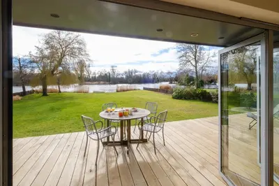 a patio with a table and chairs on a deck at Lowlands in Thorpeness
