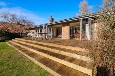 a wooden deck in front of a house at Lowlands in Thorpeness