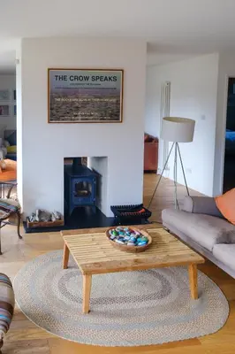 a living room with a coffee table and a fireplace at Lowlands in Thorpeness