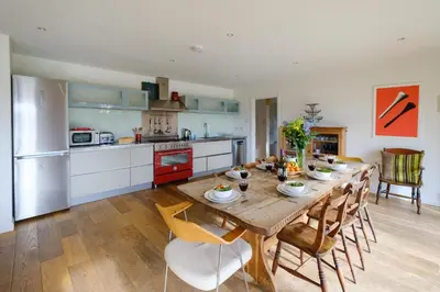 a kitchen with a wooden table and chairs in a kitchen at Lowlands in Thorpeness