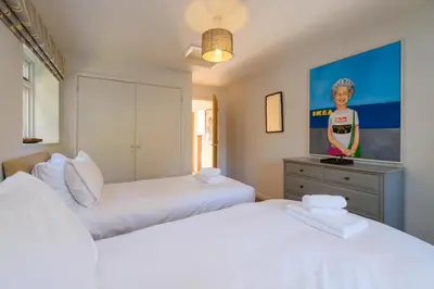 a bedroom with two beds and a painting on the wall at Lowlands in Thorpeness