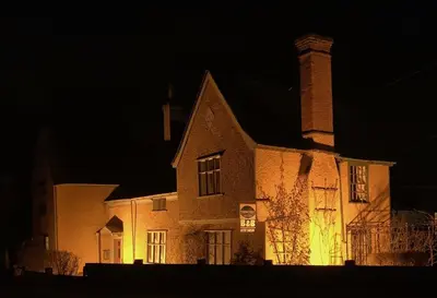 an old brick building with a chimney at night at The Bridge Street Historic Guest House in Sudbury