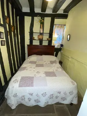 a bedroom with a bed with a checkered blanket at The Bridge Street Historic Guest House in Sudbury