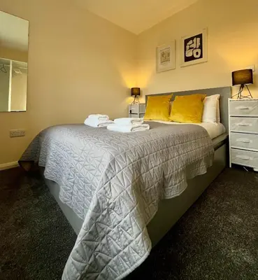 a bedroom with a large bed with yellow pillows at CENTRAL, newly refurb 2 bed flat with FREE PARKING in Cambridge