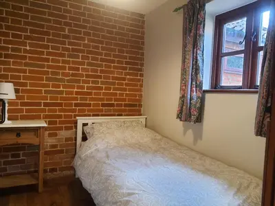 a bedroom with a brick wall and a bed at Cosy Barn Conversion 3BR (4 pax), Quiet, Close to Pin Mill in Chelmondiston