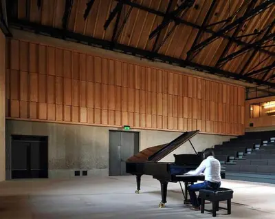 a man sitting at a piano in an auditorium at SkyFall in Grundisburgh