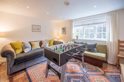 a living room with a couch and a table with a chessboard at Ivy House, Mells in Halesworth