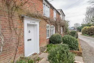 a brick house with a white door at Ivy House, Mells in Halesworth