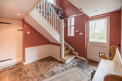 a staircase in a home with red walls at Ivy House, Mells in Halesworth