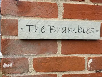 a brick wall with a sign that reads the bangles at The Brambles in Colchester