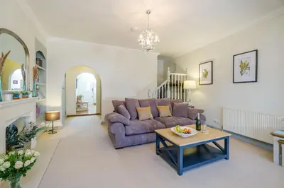 a living room with a purple couch and a table at Shearwater Cottage in Aldeburgh