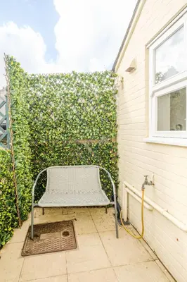 a bench sitting in front of a wall at Shearwater Cottage in Aldeburgh