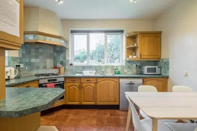 a kitchen with wooden cabinets and a table and a window at 4 Bed Central Home - Perfect Location with Parking in Cambridge