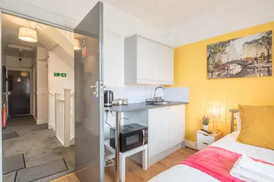 a bedroom with a bed and a small kitchen at The Modern Cambridge Studio 3 in Cambridge