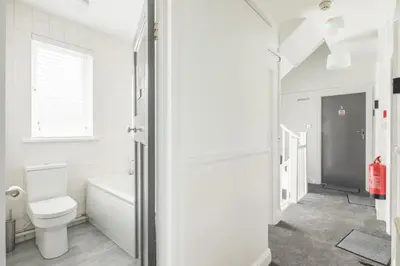 a white bathroom with a toilet and a bath tub at The Modern Cambridge Studio 3 in Cambridge