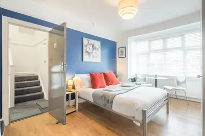 a bedroom with a bed and a blue wall at The Modern Cambridge Studio 4 in Cambridge