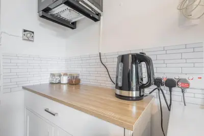 a black appliance sitting on a counter in a kitchen at The Modern Cambridge Studio 6 in Cambridge