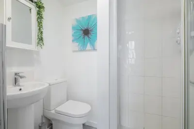 a white bathroom with a toilet and a sink at The Modern Cambridge Studio 6 in Cambridge