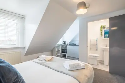a white bedroom with a bed and a bathroom at The Modern Cambridge Studio 7 in Cambridge