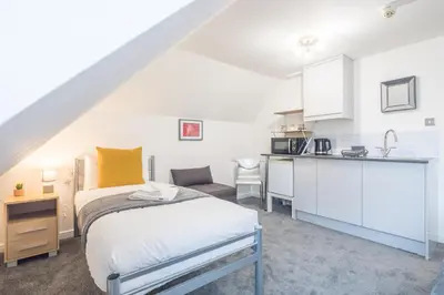 a small bedroom with a bed and a kitchen at The Modern Cambridge Studio 8 in Cambridge