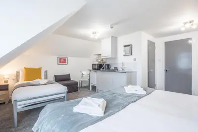 a hotel room with two beds and a kitchen at The Modern Cambridge Studio 8 in Cambridge