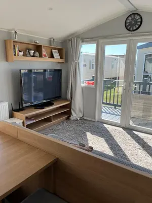 a living room with a tv and a large window at Stylish 3 Bedroom caravan near the Beach in Walton-on-the-Naze