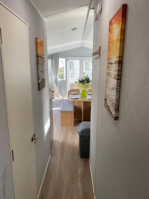a hallway leading to a living room with a toilet at Stylish 3 Bedroom caravan near the Beach in Walton-on-the-Naze