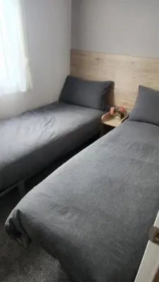 two beds sitting next to each other in a bedroom at Serenity Holiday Home in Saint Osyth