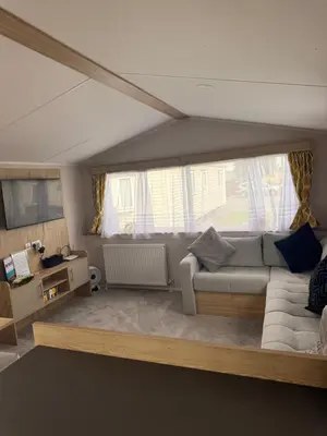 a living room with a couch and a window at Serenity Holiday Home in Saint Osyth
