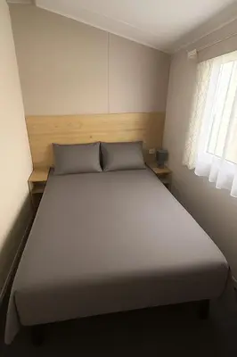a large bed in a room with a window at Serenity Holiday Home in Saint Osyth