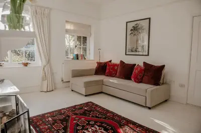 a living room with a couch and a rug at Butley Priory Cottage in Woodbridge