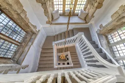 an ornate staircase in a building with windows at Butley Priory in Woodbridge