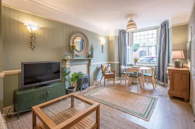 a living room with a television and a table at Villa Verde in Aldeburgh