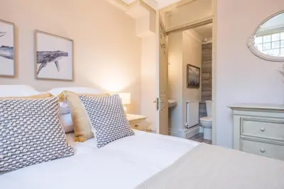 a bedroom with a white bed and a bathroom at Villa Verde in Aldeburgh