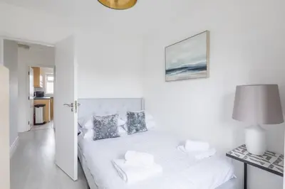 a white bedroom with a bed and a table at Lovely 2 bedroom apartment - ideal location in Cambridge
