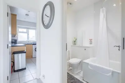 a bathroom with a toilet and a clock on the wall at Lovely 2 bedroom apartment - ideal location in Cambridge