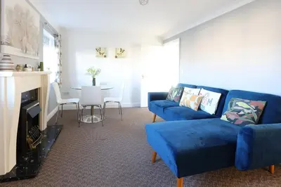 a living room with a blue couch and a table at Ipswich-Luxury-Self Catering-Town Centre-Parking in Ipswich