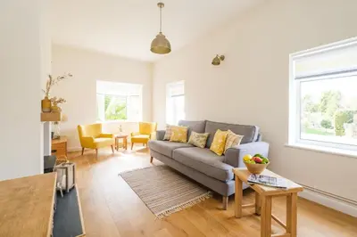 a living room with a couch and a table at The Lodge, Aldringham in Aldringham