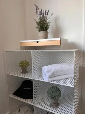 a white shelf with potted plants on it at Withers Farm Apartments in Mount Bures