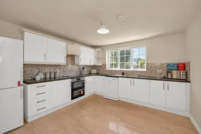an empty kitchen with white cabinets and a window at The Grange Luxe2, 5 Bedroom House,Spacious,contractor,family,Internet,free parking,group,study,relocation,easily accessible in Ipswich,Kesgrave in Ipswich