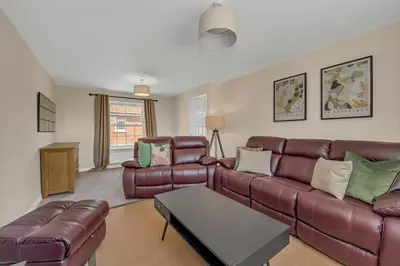 a living room with a leather couch and a table at The Grange Luxe2, 5 Bedroom House,Spacious,contractor,family,Internet,free parking,group,study,relocation,easily accessible in Ipswich,Kesgrave in Ipswich