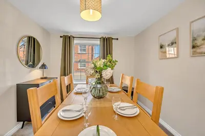 a dining room table with chairs and a vase of flowers at The Grange Luxe2, 5 Bedroom House,Spacious,contractor,family,Internet,free parking,group,study,relocation,easily accessible in Ipswich,Kesgrave in Ipswich