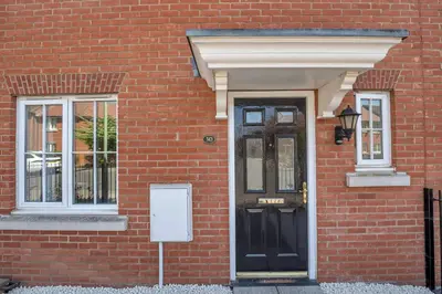 a brick building with a black door and windows at The Grange Luxe3, 4 Bedroom House,5-beds,Spacious,contractor,family,Internet,free parking,group,study,relocation,easily accessible in Ipswich,Kesgrave in Ipswich