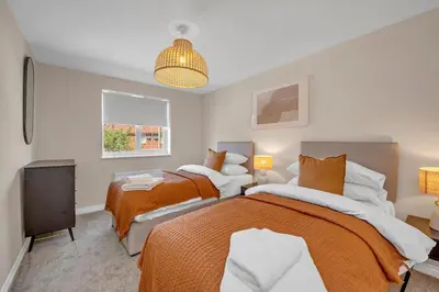a bedroom with two beds and a television at The Grange Luxe3, 4 Bedroom House,5-beds,Spacious,contractor,family,Internet,free parking,group,study,relocation,easily accessible in Ipswich,Kesgrave in Ipswich