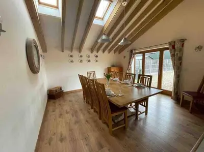 a dining room with a wooden table and chairs at Charming Norfolk Barn Conversion in Barnham Broom in Norwich