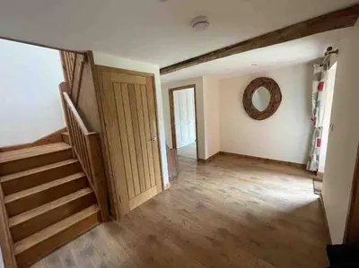 an empty room with stairs and a mirror on the wall at Charming Norfolk Barn Conversion in Barnham Broom in Norwich