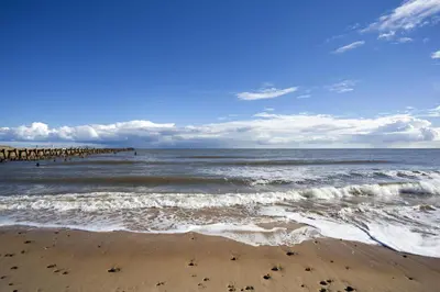 a view of the beach with a pier in the water at Stunning Lodge For Hire At Carlton Meres In Suffolk Ref 60013M in Saxmundham
